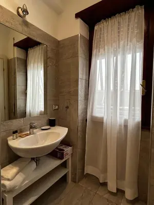 a bathroom with a sink and a shower with a mirror at Appartamento San Pietro Alla Cupola in Rome