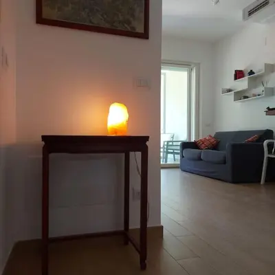a living room with a table with a lamp on it at Monolocale nuova costruzione con giardino in Rome