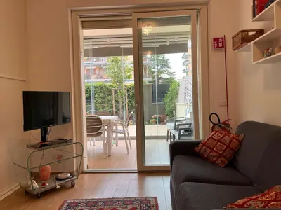 a living room with a tv and a sliding glass door at Monolocale nuova costruzione con giardino in Rome