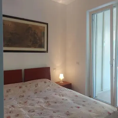 a bedroom with a bed and a lamp and a window at Monolocale nuova costruzione con giardino in Rome