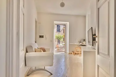 a living room with a white chair and a table at Panoramic Quirinal Penthouse in Rome