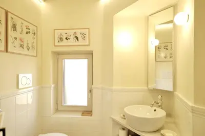 a white bathroom with a sink and a mirror at Panoramic Quirinal Penthouse in Rome