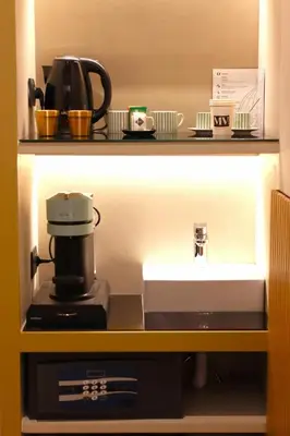 a kitchen counter with a coffee maker and a sink at Mavi Luxury Suites in Rome