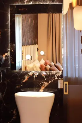 a bathroom with a large mirror above a sink at Mavi Luxury Suites in Rome