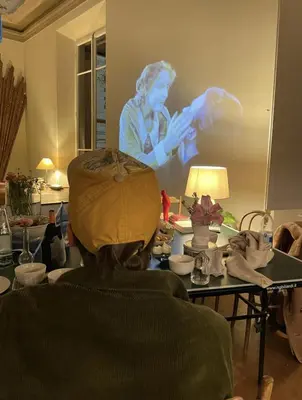 a person sitting at a table with a painting on the wall at Roma magica in Rome