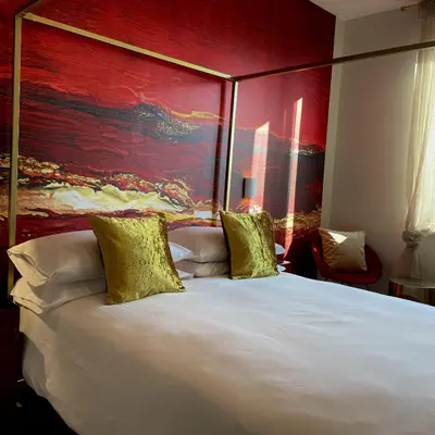 a bedroom with a large bed with a red wall at Elements in Rome