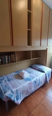 a small bed under a cabinet in a room at Attico Aventino in Rome