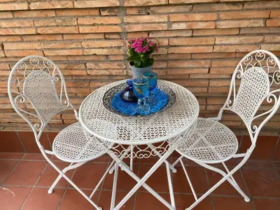 a white table with two chairs and a vase with flowers at Attico Aventino in Rome