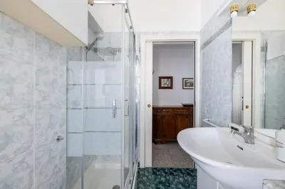 a bathroom with a sink and a glass shower at Piazza Caprera - Family Apartment in Rome