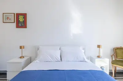 a bedroom with a blue bed and a chair at Piazza Caprera - Family Apartment in Rome