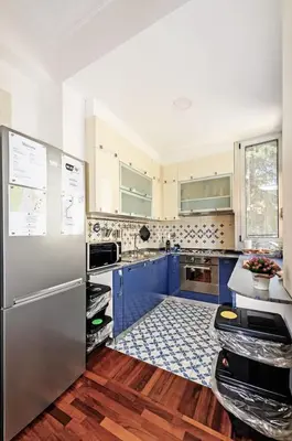 a kitchen with blue cabinets and a stainless steel refrigerator at E&L apt 150sqm 3BR Metro 30m Park in Rome