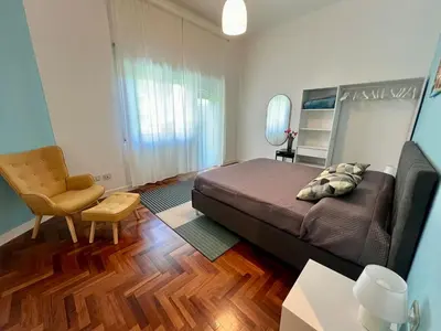 a bedroom with a bed and a chair in a room at E&L apt 150sqm 3BR Metro 30m Park in Rome