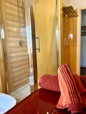 a bathroom with a shower and a chair with a table at E&L apt 150sqm 3BR Metro 30m Park in Rome
