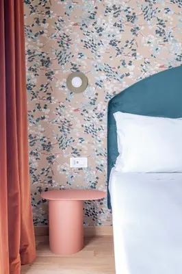 a bedroom with a bed and a table next to a wall at UNICO Suite - GRUPPO BLAM in Rome