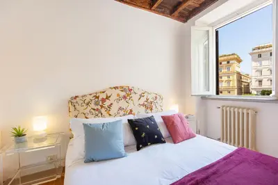 a bedroom with a bed with pillows and a window at Santa Margherita by Rental in Rome in Rome