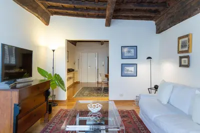 a living room with a white couch and a glass table at Santa Margherita by Rental in Rome in Rome