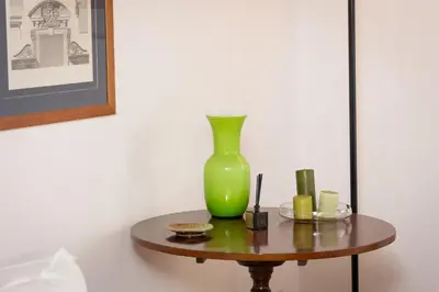 a green vase sitting on top of a table at Santa Margherita by Rental in Rome in Rome