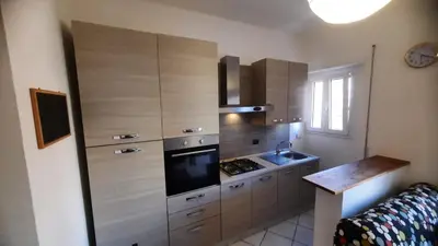 a kitchen with wooden cabinets and a stove top oven at Urban Welcome Metro Battistini in Rome