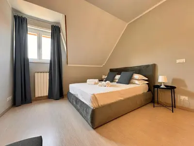 a bedroom with a large bed with black curtains at Lux Apartment Tuscolano in Rome