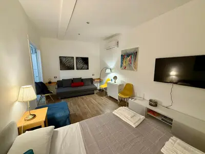 a living room with a bed and a couch and a television at Rosetta Lovely House - Pantheon - Roma in Rome