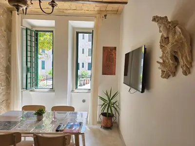 a dining room with a table and a tv on a wall at Testaccio Charme Apt in Rome