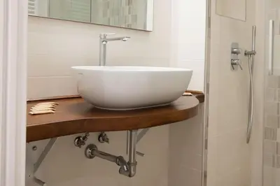 a white bowl sink on a wooden counter in a bathroom at Fiqus in Rome