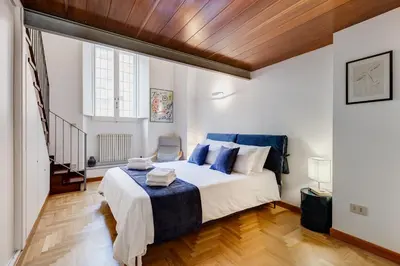 a bedroom with a large bed with blue pillows at Casa Valentina - Oasi di tranquillità e stile a Testaccio in Rome