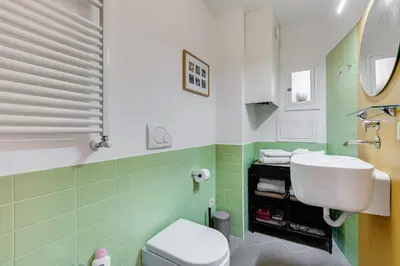 a green bathroom with a sink and a toilet at Casa Valentina - Oasi di tranquillità e stile a Testaccio in Rome