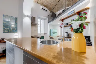 a kitchen with a yellow vase with flowers on a counter at Casa Valentina - Oasi di tranquillità e stile a Testaccio in Rome