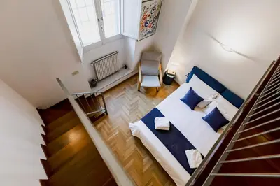 an attic bedroom with a bed and a staircase at Casa Valentina - Oasi di tranquillità e stile a Testaccio in Rome