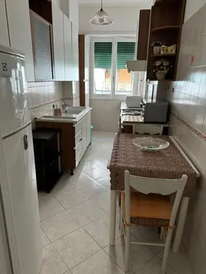a kitchen with a table and a sink and a refrigerator at Silihome, Trastevere, Piazza della Radio in Rome