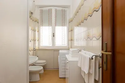 a white bathroom with a toilet and a sink at VIVA Rome Apartment 