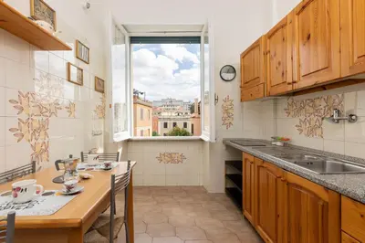 a kitchen with a table and a large window at VIVA Rome Apartment 