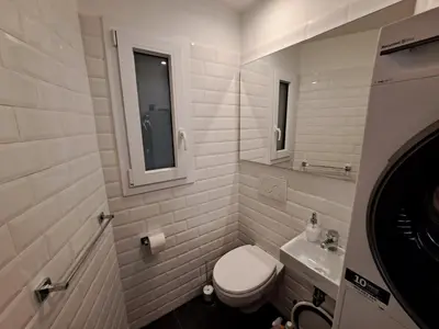 a white bathroom with a toilet and a sink at Casa Lilli in Rome