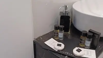 a bathroom with a sink and four bottles of perfume at Mazzini City Center Apartment - Vaticano - Foro Italico - Stadio Olimpico-Rai Delle Vittorie in Rome
