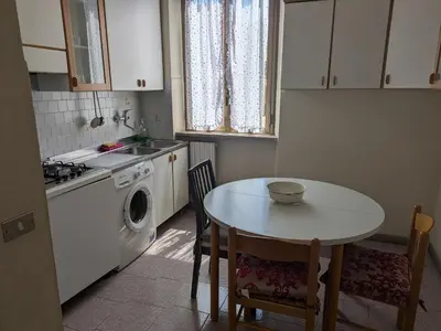a kitchen with a table and a sink and a washing machine at Torpigna house in Rome