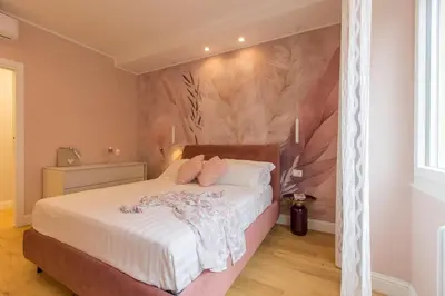 a bedroom with a bed with white sheets and pink pillows at INTERNO 10 - Musei Vaticani in Rome