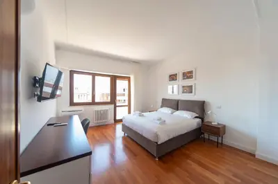 a bedroom with a bed and a desk with a computer at Cardinal Mistrangelo - next to the metro station, large and comfortable penthouse with terrace in Rome