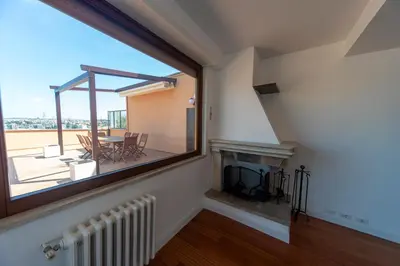 a living room with a large window and a fireplace at Cardinal Mistrangelo - next to the metro station, large and comfortable penthouse with terrace in Rome