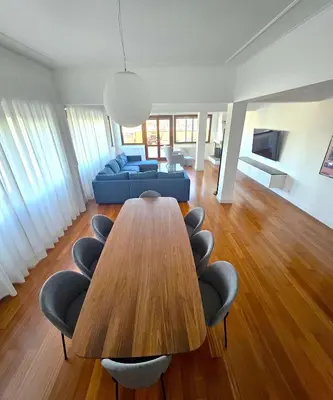 a living room with a wooden table and chairs at Cardinal Mistrangelo - next to the metro station, large and comfortable penthouse with terrace in Rome