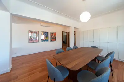 a conference room with a wooden table and blue chairs at Cardinal Mistrangelo - next to the metro station, large and comfortable penthouse with terrace in Rome