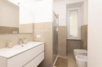 a white bathroom with a sink and a toilet at Barca House in Rome