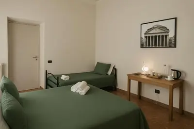 a room with two beds and a couch and a table at Colosseo Rooms Rome in Rome