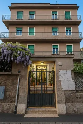 a building with a gate and purple flowers at Colosseo Rooms Rome in Rome
