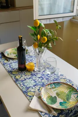 a table with plates and a vase of flowers on it at CasaLetizia A Roma con piacere! in Rome