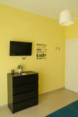 a living room with a tv on a yellow wall at CasaLetizia A Roma con piacere! in Rome