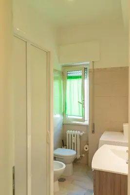 a bathroom with a toilet and a sink and a window at CasaLetizia A Roma con piacere! in Rome