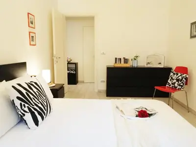 a bedroom with a white bed and a red chair at Appiano Vatican city, lovely apartment, 2 room ,Wi-fi 250 mbps in Rome