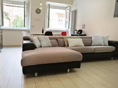 a brown couch in a living room with two windows at Appiano Vatican city, lovely apartment, 2 room ,Wi-fi 250 mbps in Rome
