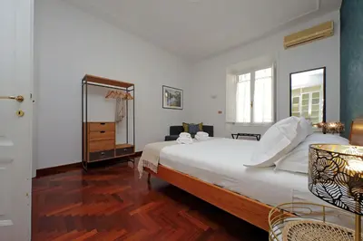 a bedroom with a large white bed and a mirror at 4BNB - Vittorio Emanuele Apartment in Rome